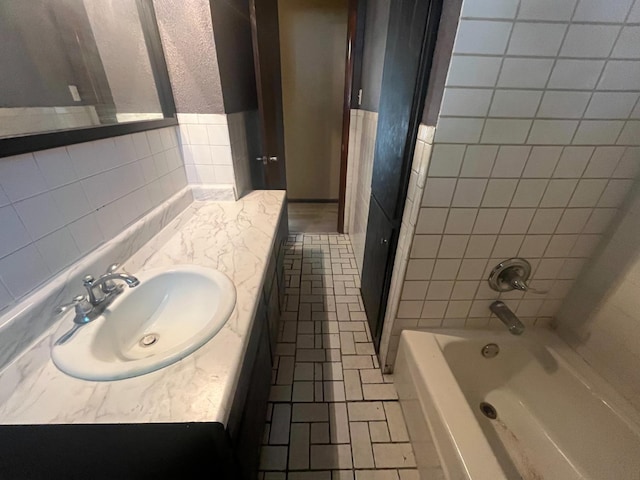 bathroom featuring vanity and tile walls