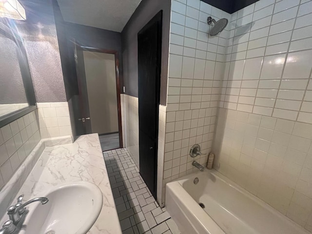 bathroom featuring tiled shower / bath, sink, tile walls, and tile patterned floors