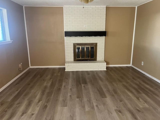 unfurnished living room with dark hardwood / wood-style flooring, a textured ceiling, and a fireplace