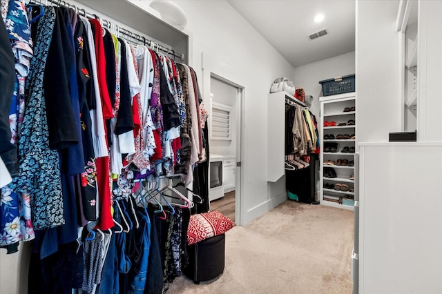 spacious closet featuring washer / clothes dryer and carpet floors