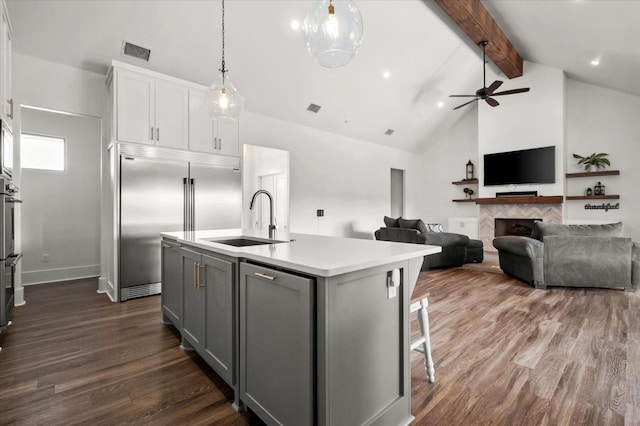 kitchen with sink, gray cabinets, white cabinets, a center island with sink, and decorative light fixtures