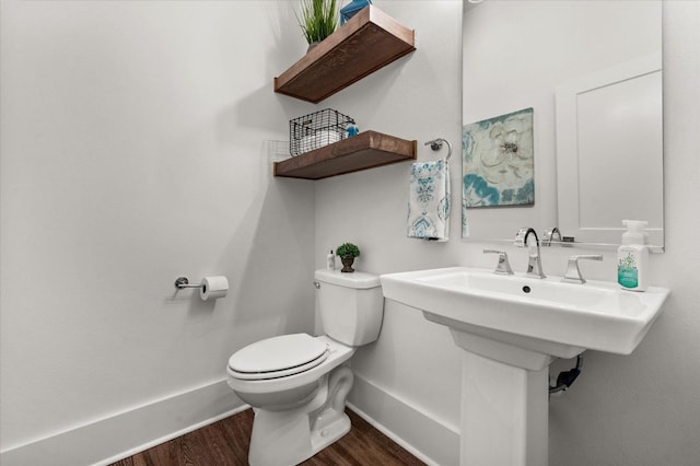 bathroom with hardwood / wood-style floors and toilet