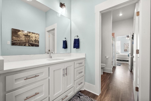 bathroom featuring vanity, hardwood / wood-style floors, ceiling fan, and toilet