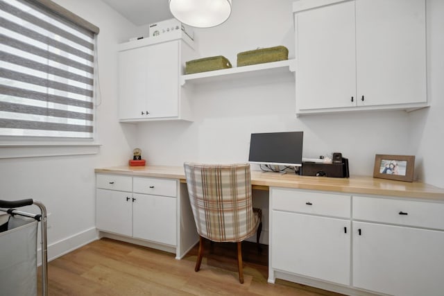 office area with built in desk and light hardwood / wood-style flooring