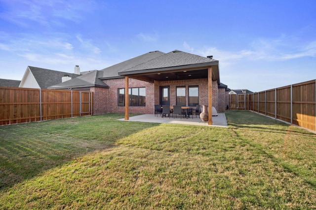 rear view of property featuring a patio and a lawn