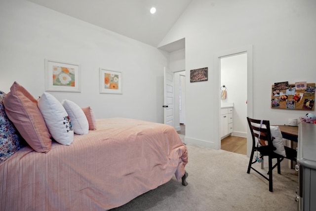 carpeted bedroom with high vaulted ceiling and ensuite bathroom