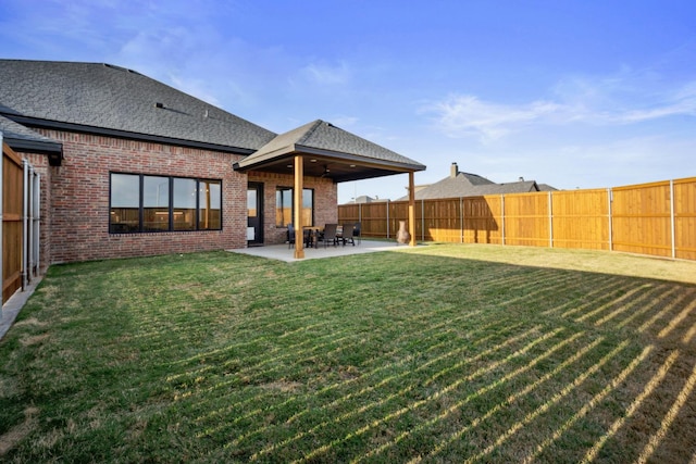 back of property with a lawn and a patio area