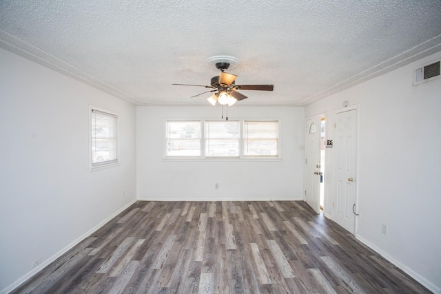 unfurnished room with dark hardwood / wood-style flooring, a textured ceiling, and a healthy amount of sunlight