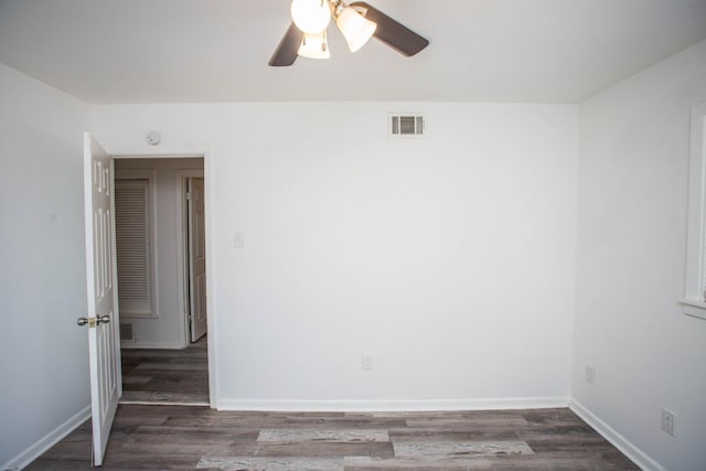 empty room featuring dark wood-type flooring and ceiling fan