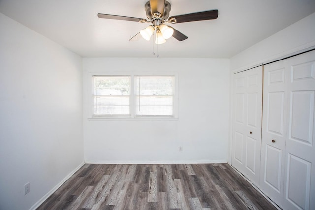 unfurnished bedroom featuring dark wood-type flooring, a closet, and ceiling fan