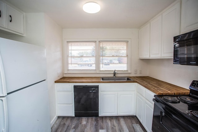 kitchen featuring dark hardwood / wood-style floors, wood counters, white cabinetry, sink, and black appliances