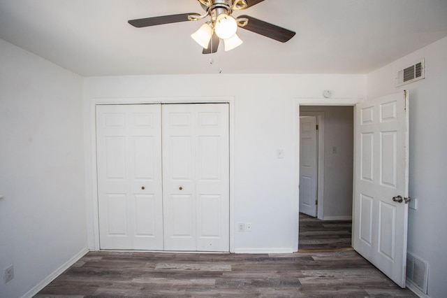 unfurnished bedroom featuring dark hardwood / wood-style floors, ceiling fan, and a closet