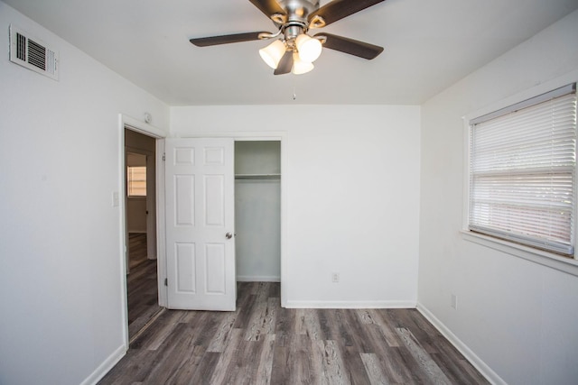 unfurnished bedroom featuring dark hardwood / wood-style flooring, a closet, and ceiling fan