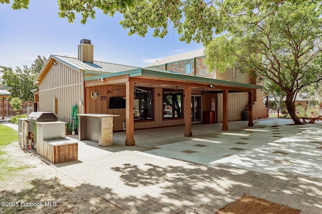 5412 20th St, Lubbock, TX 79407 - back of house featuring a chimney, a patio area, and metal roof