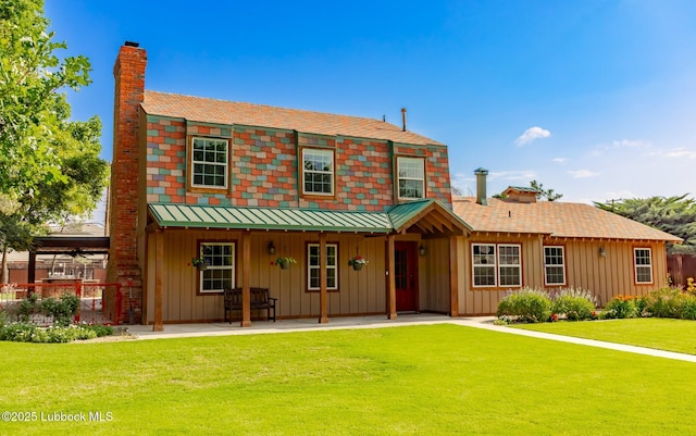 5412 20th St, Lubbock, TX 79407 - view of front of home featuring a chimney, board and batten siding, a front yard, and a patio area
