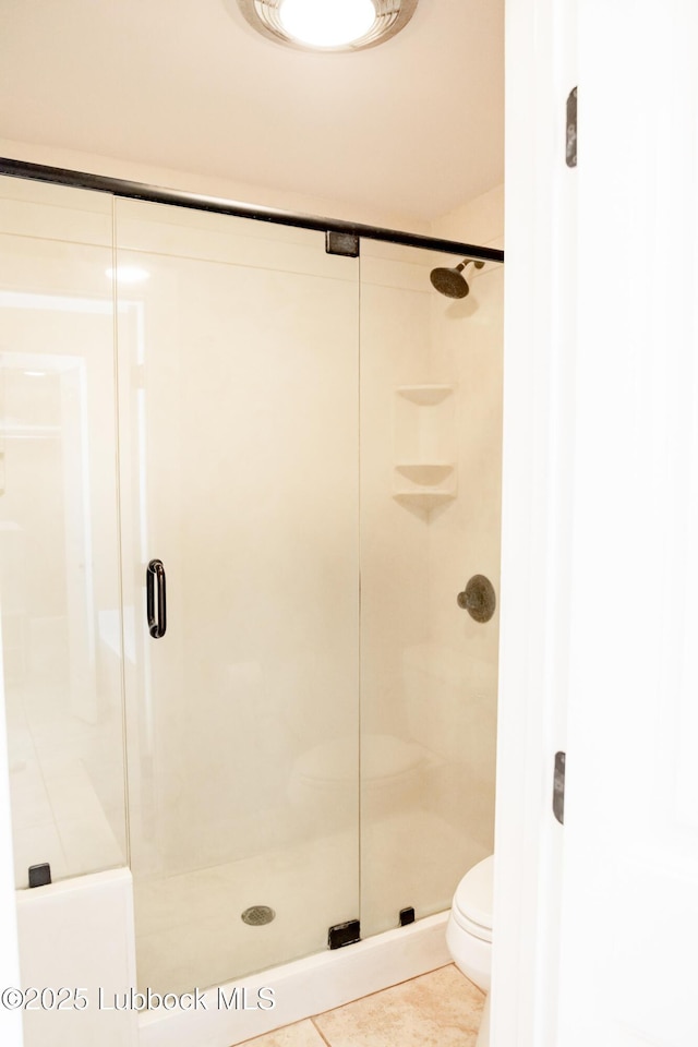 5412 20th St, Lubbock, TX 79407 - bathroom with a stall shower, tile patterned floors, and toilet
