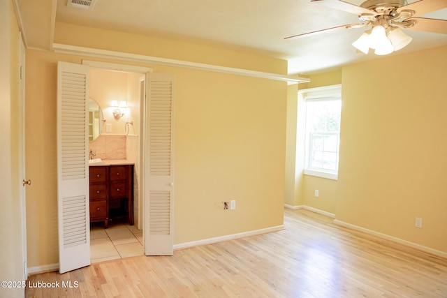 5412 20th St, Lubbock, TX 79407 - unfurnished bedroom featuring light wood-type flooring, ensuite bath, baseboards, and ceiling fan