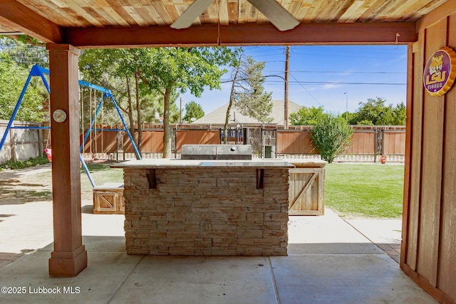 5412 20th St, Lubbock, TX 79407 - fenced backyard featuring an outdoor kitchen, a playground, a patio area, and ceiling fan