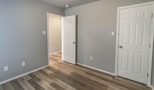 unfurnished bedroom with dark hardwood / wood-style flooring