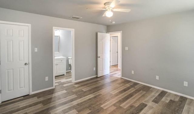 unfurnished bedroom with dark wood-type flooring, ceiling fan, and ensuite bath