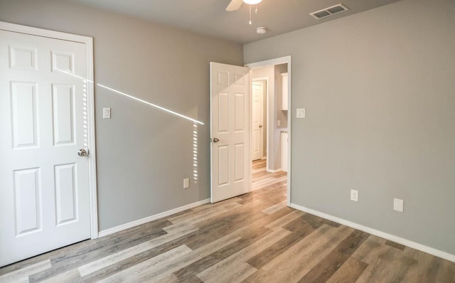 unfurnished bedroom featuring hardwood / wood-style floors and ceiling fan