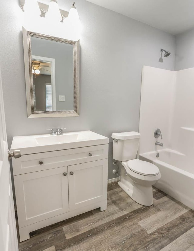 full bathroom featuring vanity, hardwood / wood-style floors, bathtub / shower combination, and toilet