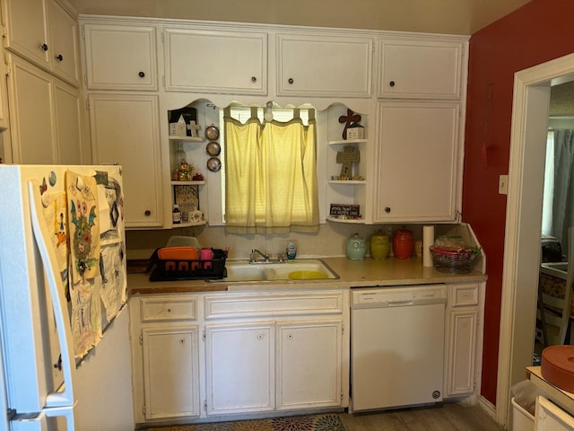 kitchen with white cabinetry, white appliances, and sink