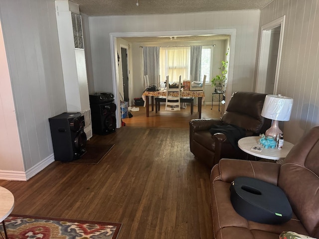 living room featuring dark hardwood / wood-style flooring and a textured ceiling