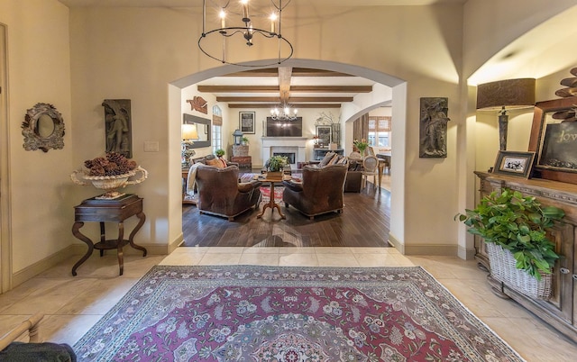 interior space with light tile patterned floors, beam ceiling, and a chandelier