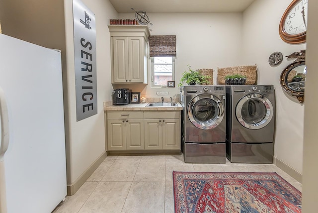 clothes washing area with cabinets, washing machine and dryer, sink, and light tile patterned flooring