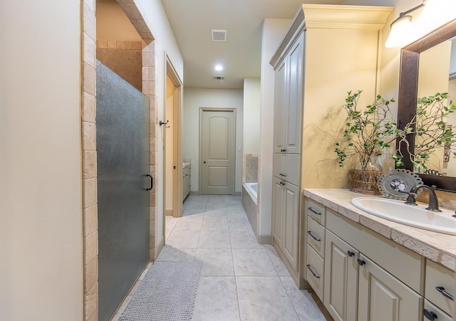 bathroom featuring shower with separate bathtub, tile patterned floors, and vanity