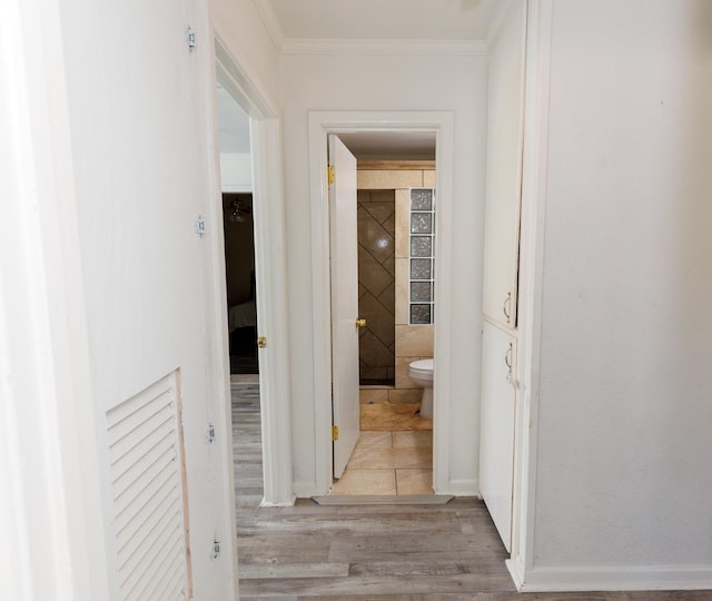 corridor featuring ornamental molding and light hardwood / wood-style flooring