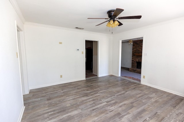 unfurnished room with ceiling fan, ornamental molding, wood-type flooring, and a fireplace