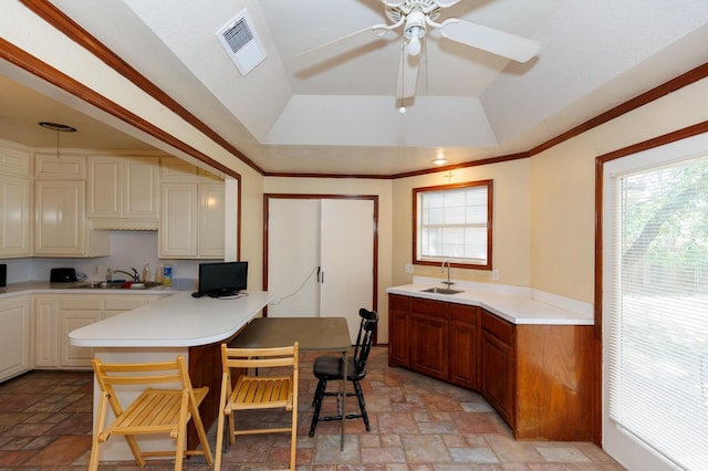 kitchen with cream cabinets, sink, and a breakfast bar area