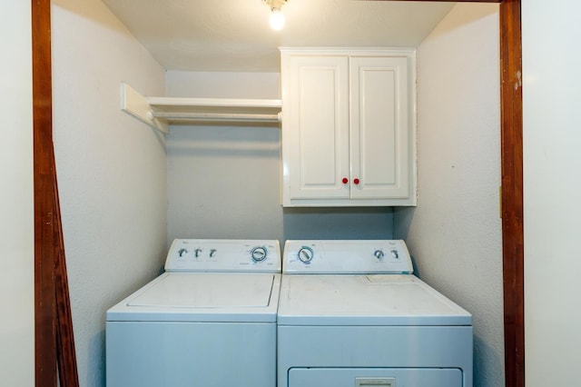 washroom featuring cabinets and washer and clothes dryer