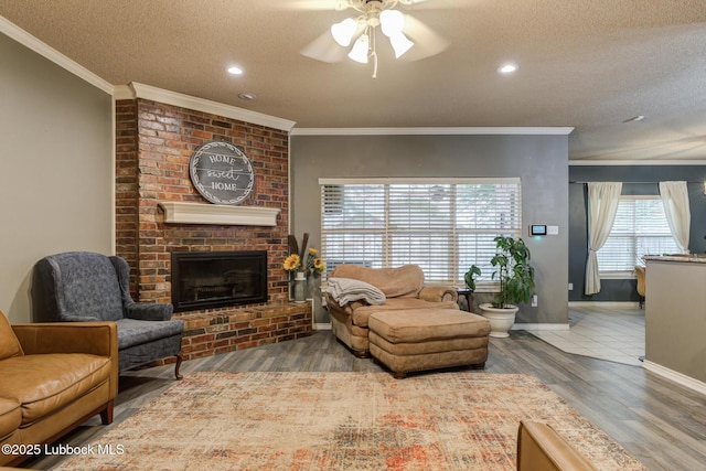 5516 101st Pl, Lubbock, TX 79424 - living room with ceiling fan, a textured ceiling, baseboards, wood finished floors, and a fireplace