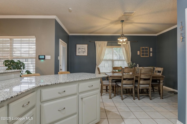 5516 101st Pl, Lubbock, TX 79424 - kitchen featuring plenty of natural light, light tile patterned floors, a textured ceiling, white cabinets, and crown molding