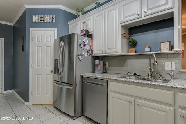 5516 101st Pl, Lubbock, TX 79424 - kitchen featuring appliances with stainless steel finishes, light tile patterned floors, a sink, crown molding, and white cabinetry