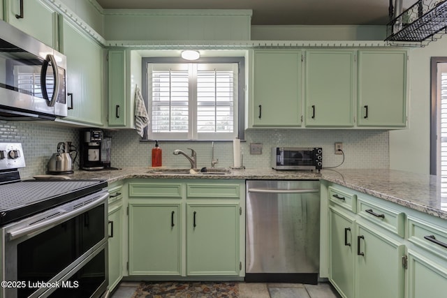 2608 74th Pl, Lubbock, TX 79423 - kitchen featuring appliances with stainless steel finishes, green cabinets, decorative backsplash, and plenty of natural light