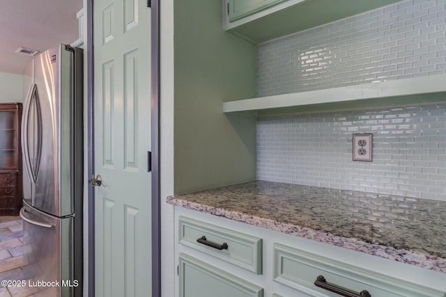 2608 74th Pl, Lubbock, TX 79423 - kitchen featuring freestanding refrigerator, backsplash, and light stone counters