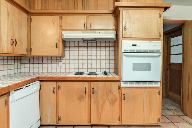 kitchen featuring white appliances, tile counters, and decorative backsplash