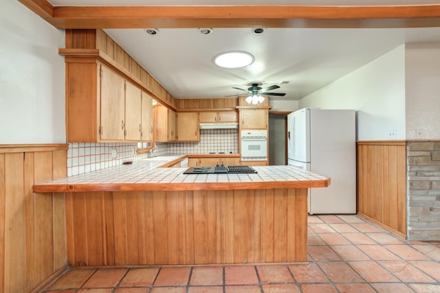 kitchen with ceiling fan, tile counters, white appliances, and kitchen peninsula