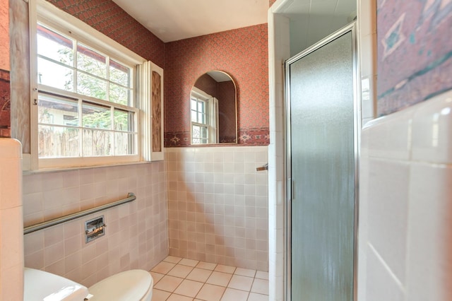 bathroom with tile patterned flooring, tile walls, an enclosed shower, and toilet