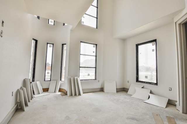 empty room featuring a healthy amount of sunlight and a high ceiling