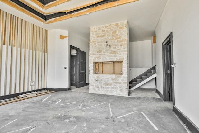 unfurnished room with concrete flooring and a fireplace