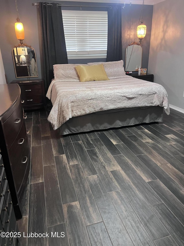 bedroom featuring baseboards and dark wood finished floors