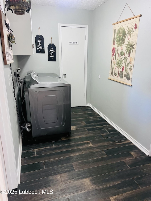 laundry room with dark wood-style flooring, cabinet space, baseboards, and washer / dryer