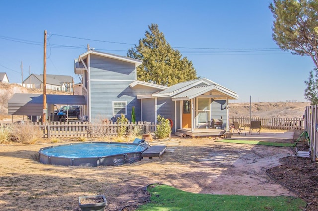 rear view of property with a fenced in pool and a patio area