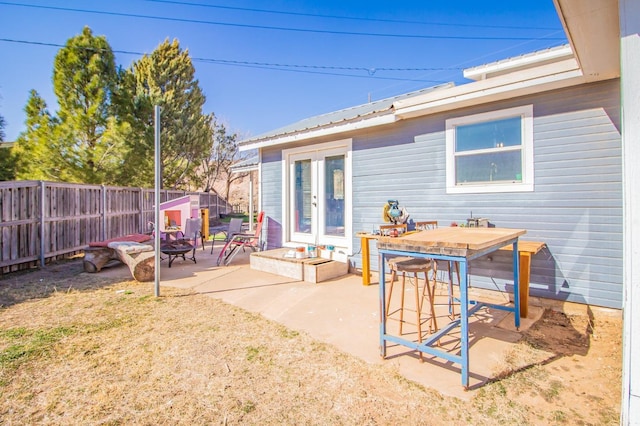 rear view of house with french doors, a patio area, and an outdoor fire pit