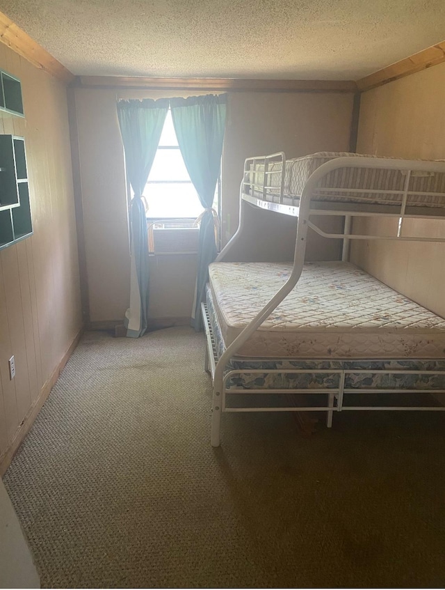 unfurnished bedroom with carpet floors, a textured ceiling, and wood walls